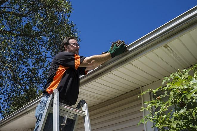 a worker conducting maintenance on a gutter in Alviso